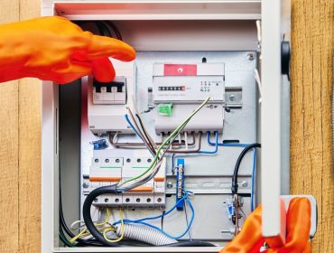 An,Electrician,Wearing,Protective,Dielectric,Gloves,Turns,Off,Power,Supply