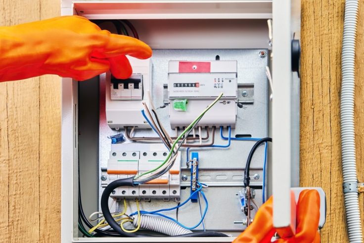 An,Electrician,Wearing,Protective,Dielectric,Gloves,Turns,Off,Power,Supply