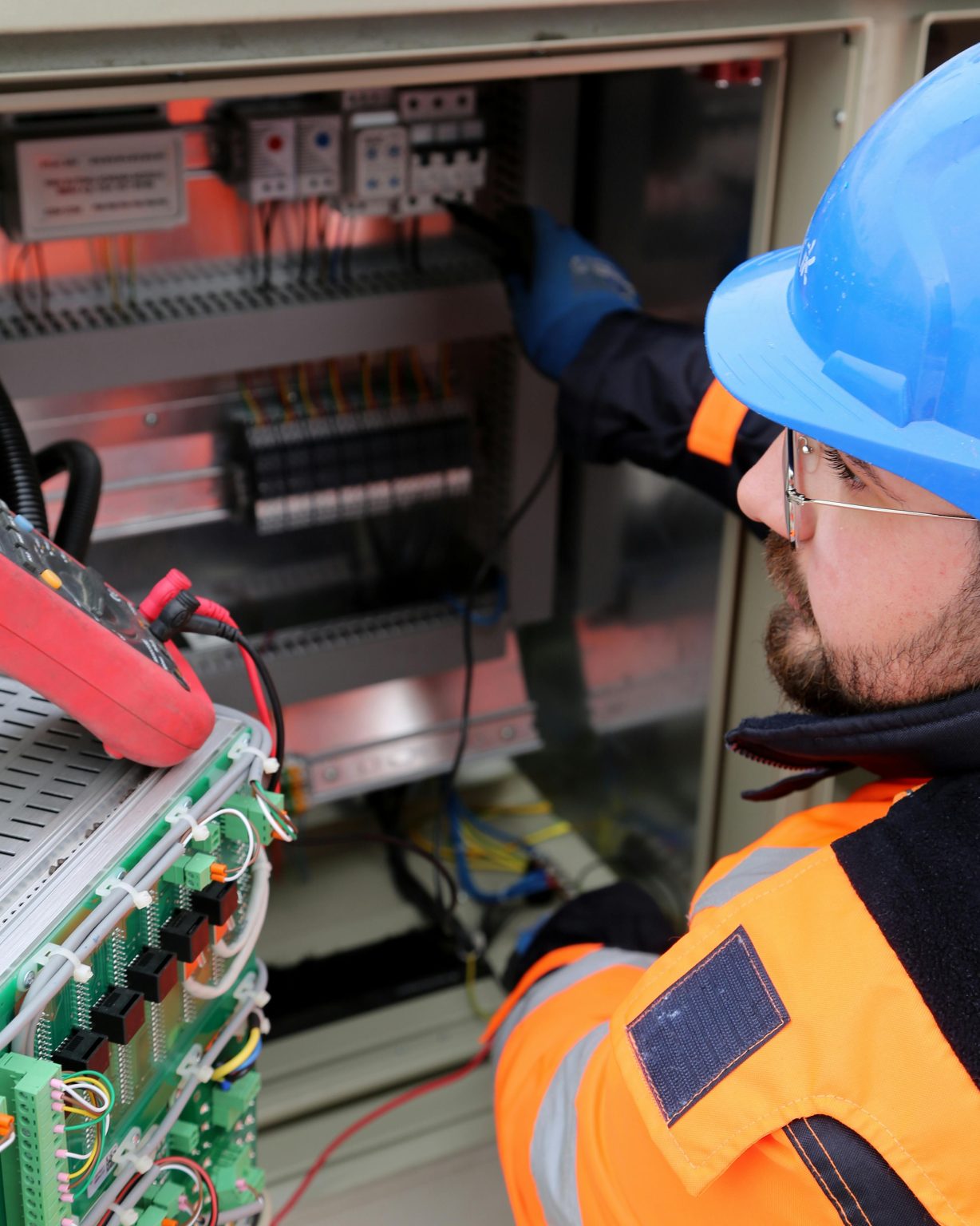 Electrician testing a commercial control panel with a multimeter