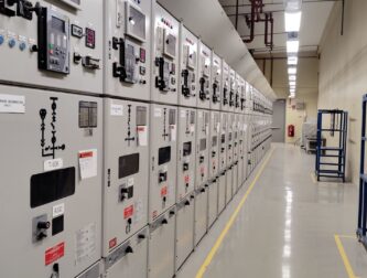Row of commercial medium voltage switchgear cubicles with arc flash warning labels in a facility electrical room