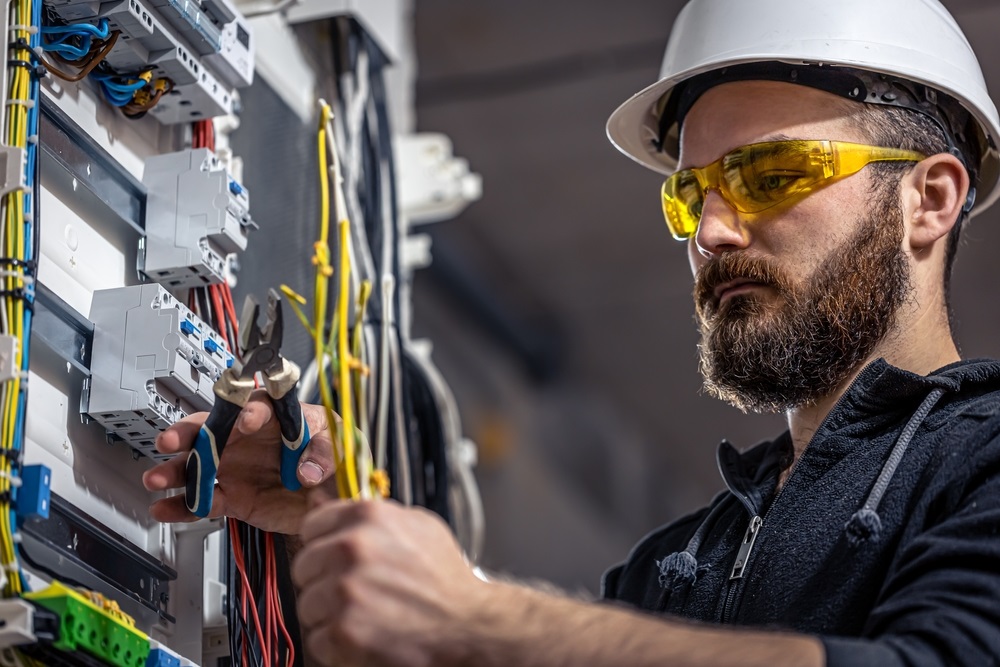 Licensed electrician checking a home electrical panel after knob and tube wiring was found during a home inspection